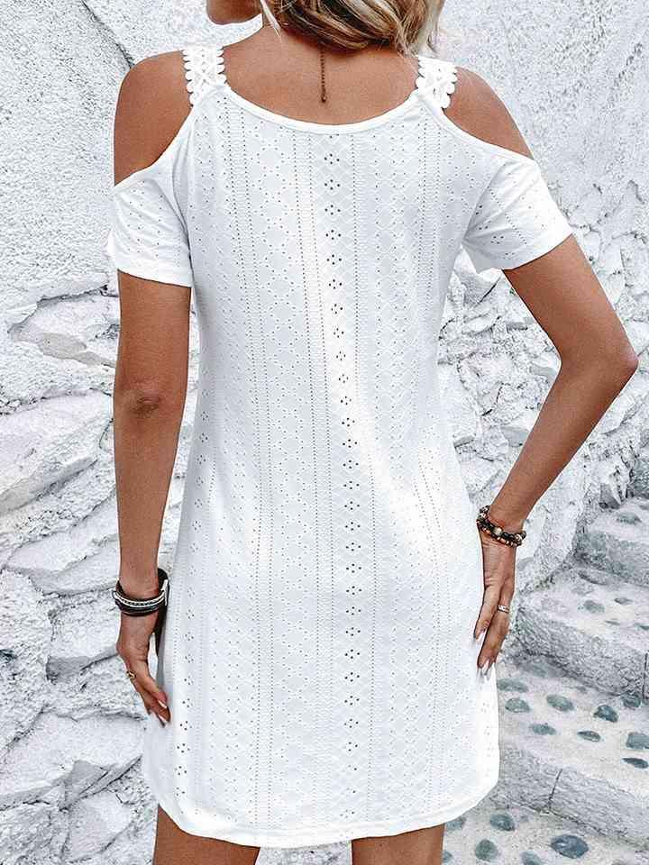 a woman wearing a white dress with cut outs