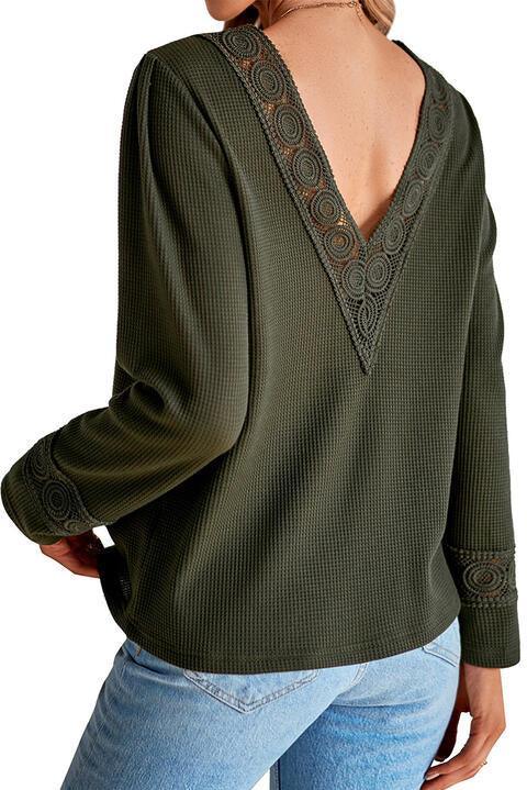 a woman wearing a green sweater and jeans