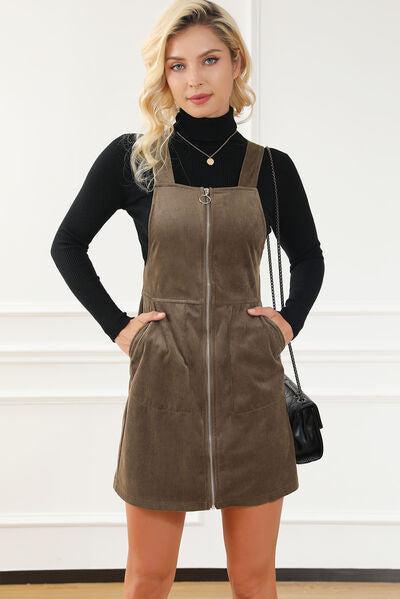 a woman standing in a room wearing a brown suede dress