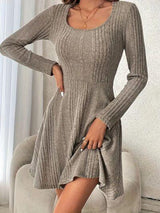 a woman in a gray sweater dress posing for a picture