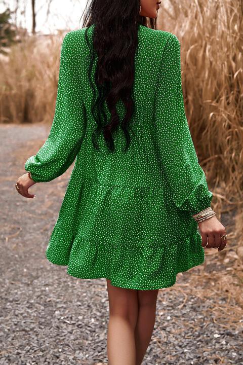 a woman in a green dress walking down a dirt road