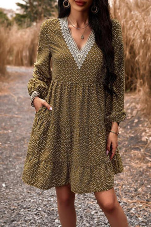 a woman standing on a dirt road wearing a dress