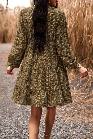 a woman walking down a dirt road in a dress