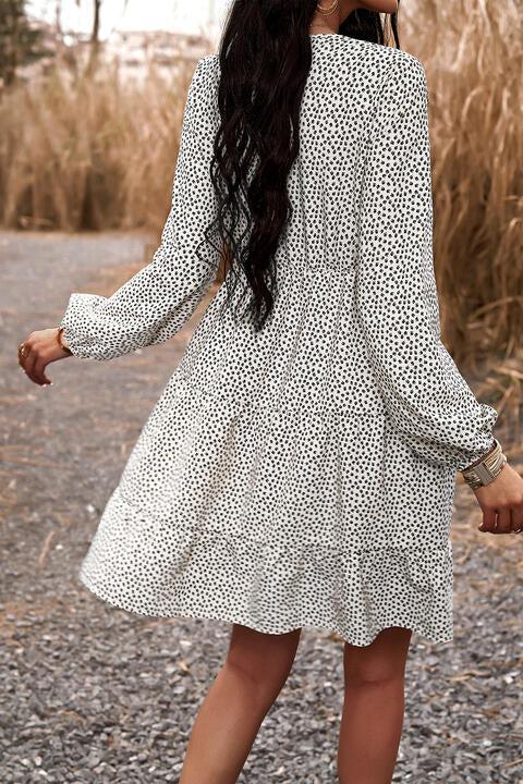 a woman in a white and black dress standing on a gravel road