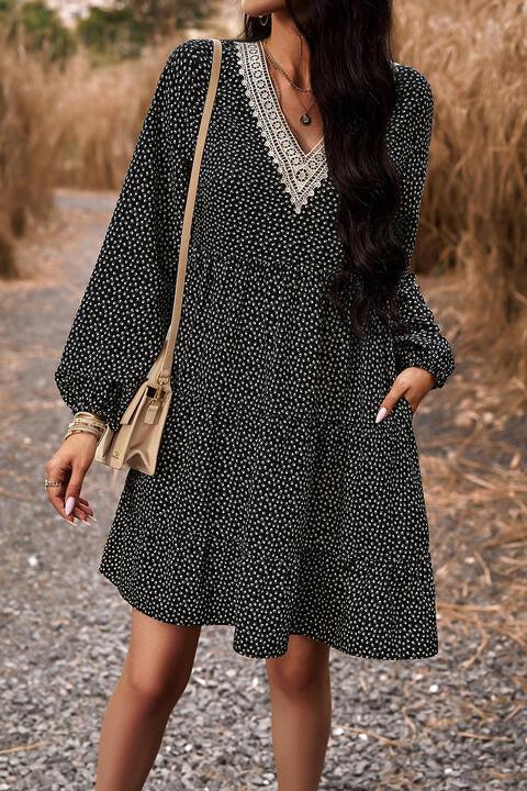 a woman standing on a dirt road wearing a black and white dress