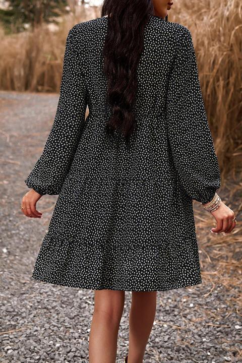 a woman in a black and white dress walking down a road