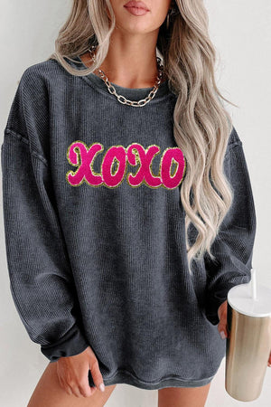 a woman wearing a grey sweater with the word boo on it