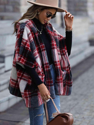 a woman wearing a hat and a plaid coat