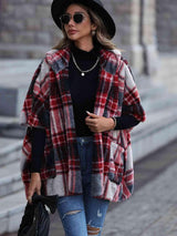 a woman walking down a street wearing a plaid coat