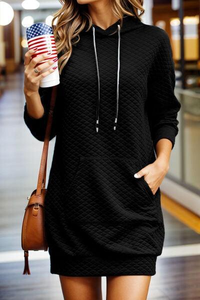 a woman in a black sweater dress holding a cup of coffee