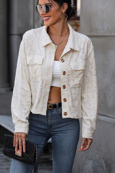 a woman wearing a white jacket and jeans