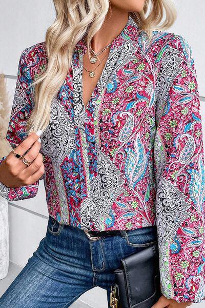 a woman wearing a pink and blue paisley shirt