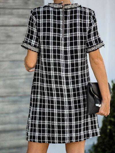 a woman in a black and white plaid dress