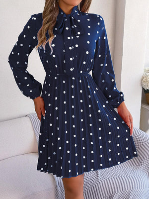 a woman wearing a blue dress with white polka dots