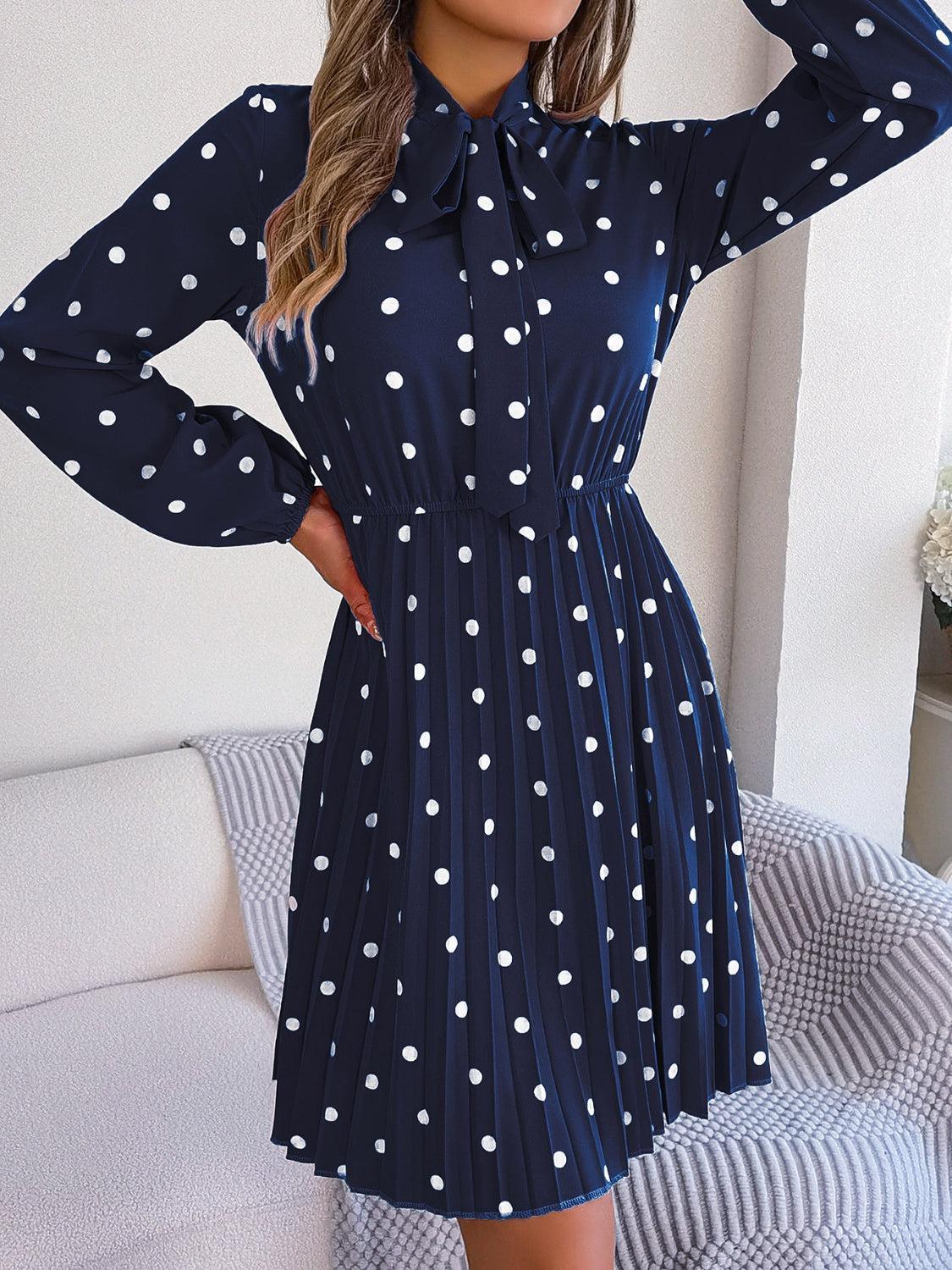 a woman in a blue dress with white polka dots