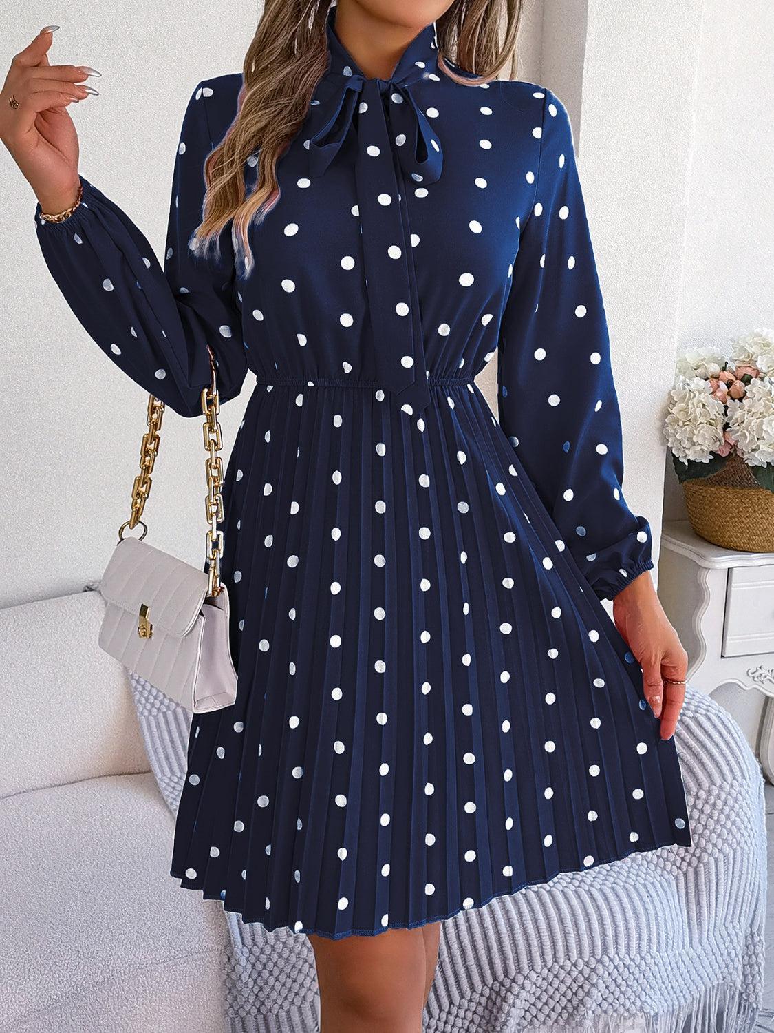 a woman wearing a blue dress with white polka dots