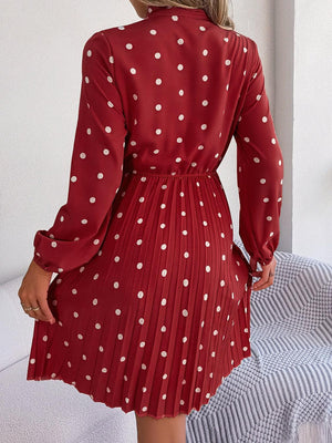 a woman wearing a red dress with white polka dots