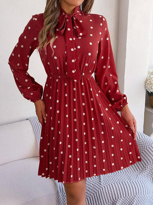 a woman wearing a red dress with white polka dots