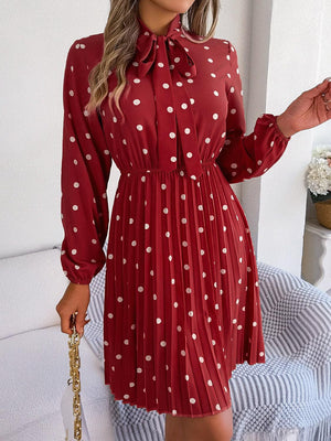 a woman wearing a red dress with white polka dots