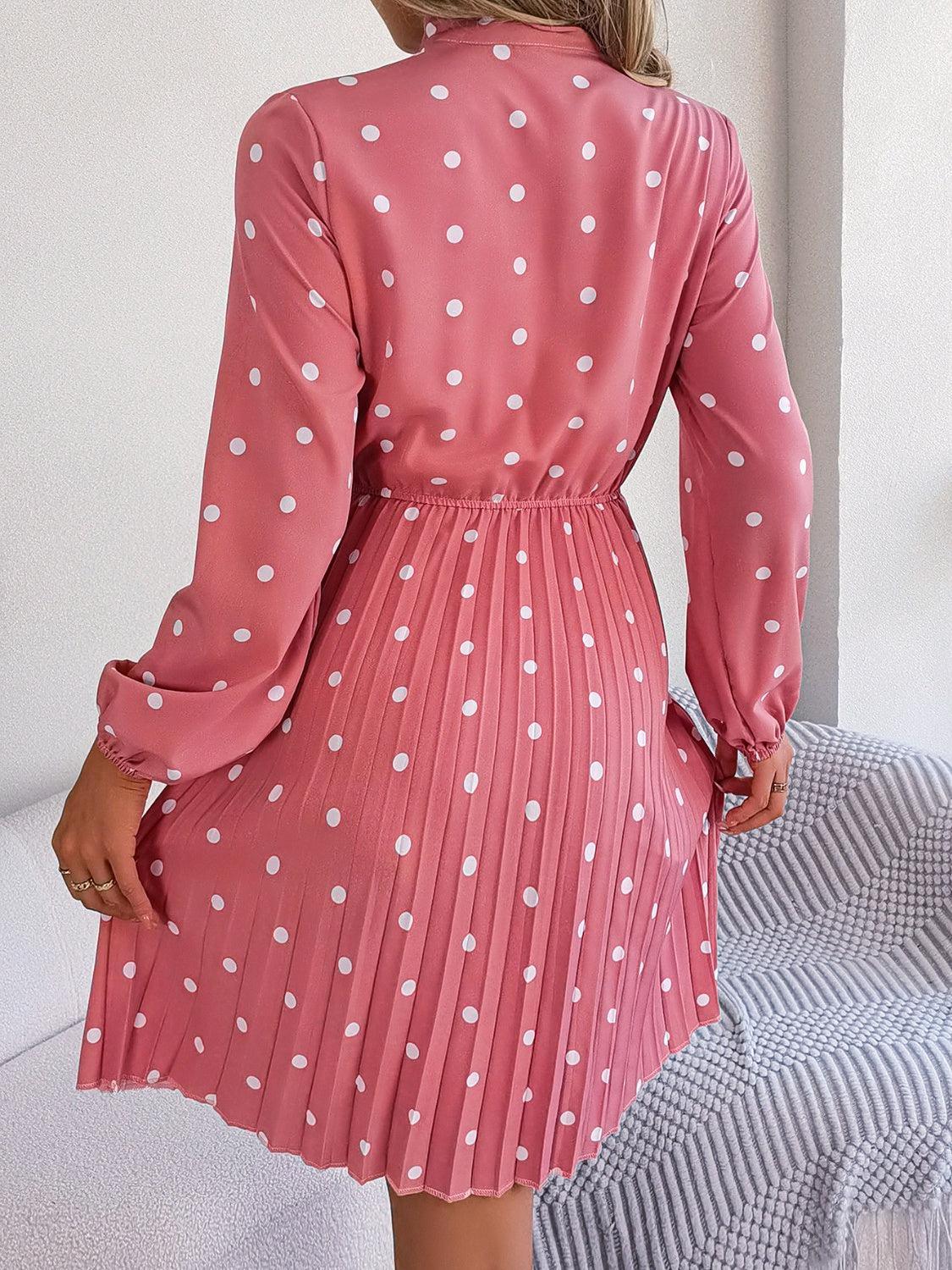 a woman wearing a pink dress with white polka dots