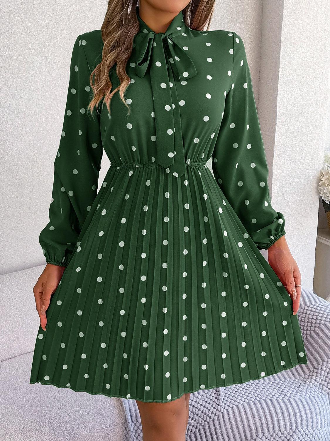a woman wearing a green dress with white polka dots
