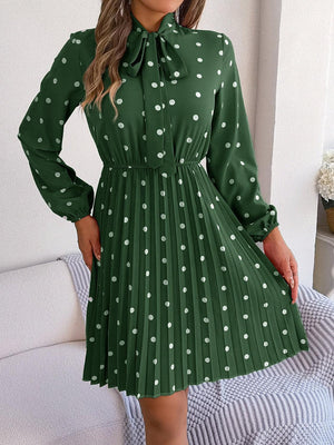 a woman wearing a green dress with white polka dots