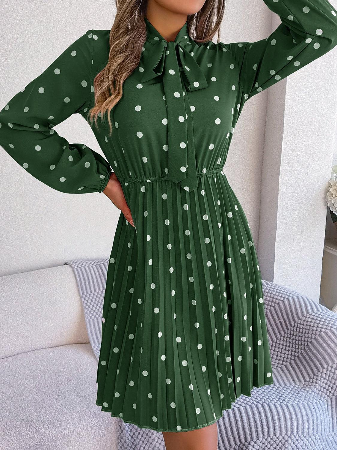 a woman wearing a green dress with white polka dots