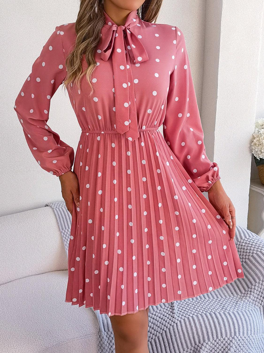 a woman wearing a pink dress with white polka dots