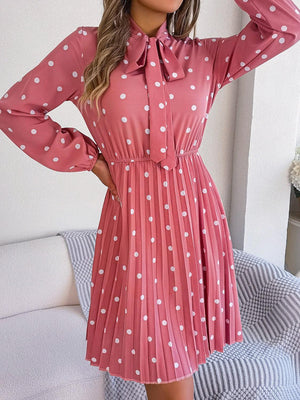 a woman wearing a pink dress with white polka dots