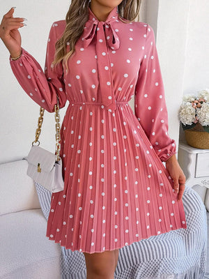 a woman wearing a pink dress with white polka dots