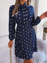 a woman wearing a blue dress with white polka dots