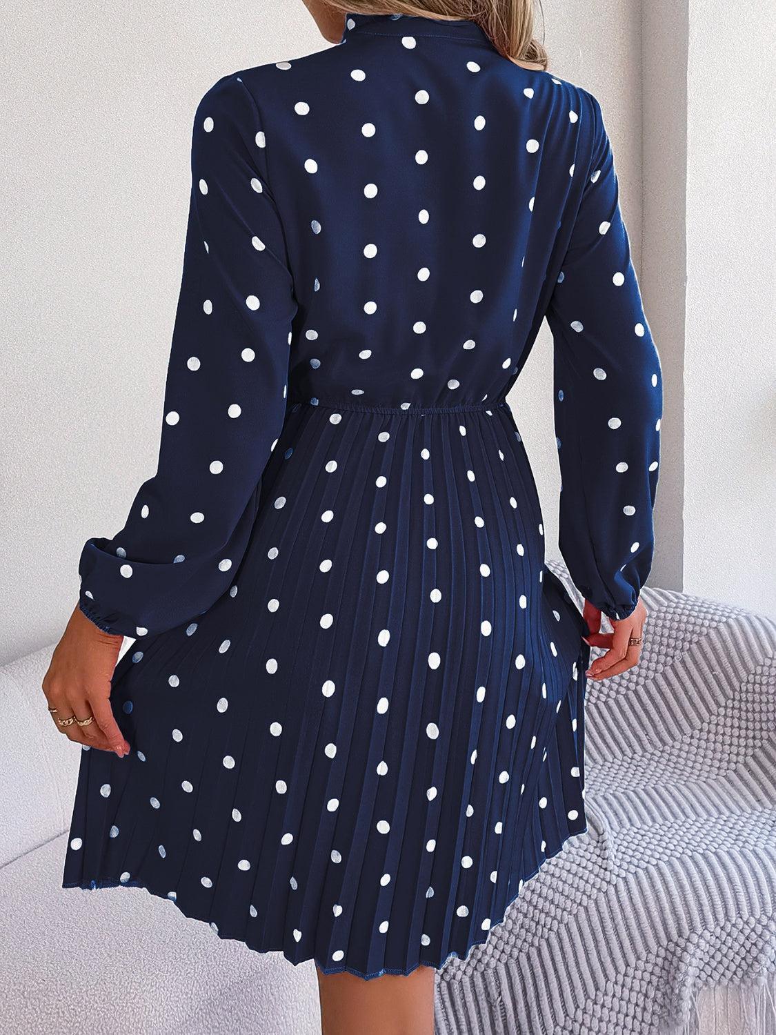 a woman in a blue dress with white polka dots