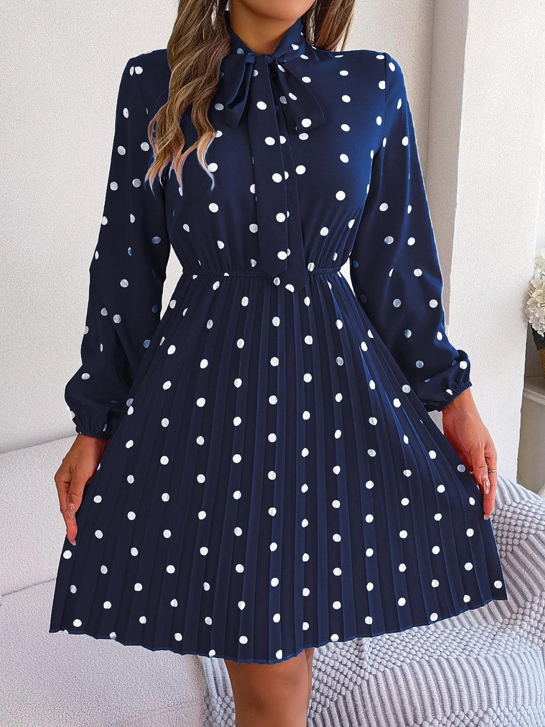 a woman wearing a blue dress with white polka dots