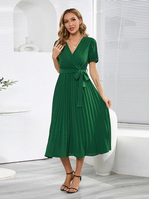 a woman in a green dress posing for a picture