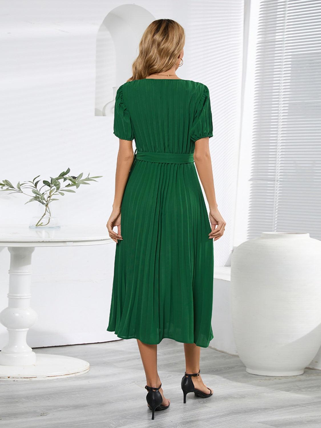 a woman in a green dress standing in a room