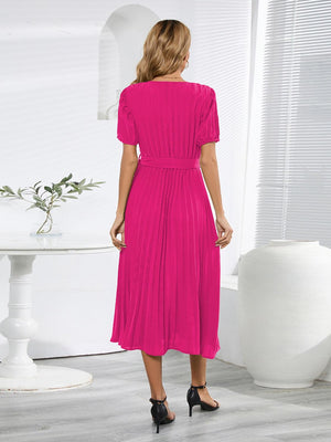 a woman in a bright pink dress standing in a room