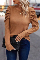 a woman wearing a brown sweater and jeans