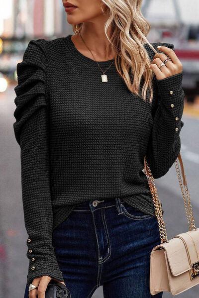 a woman wearing a black sweater and jeans