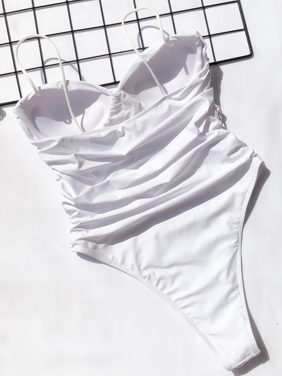 a white swimsuit laying on top of a metal rack