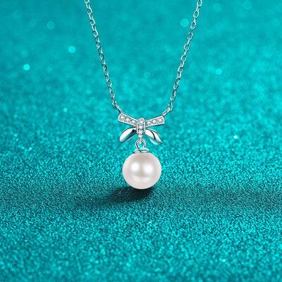 a necklace with a pearl and a bow on it