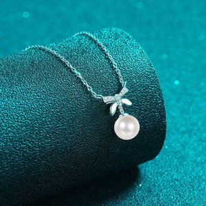 a necklace with a pearl hanging from it