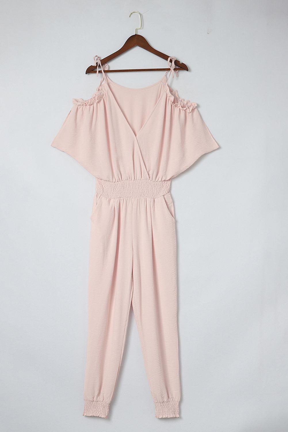 a pink jumpsuit hanging on a hanger