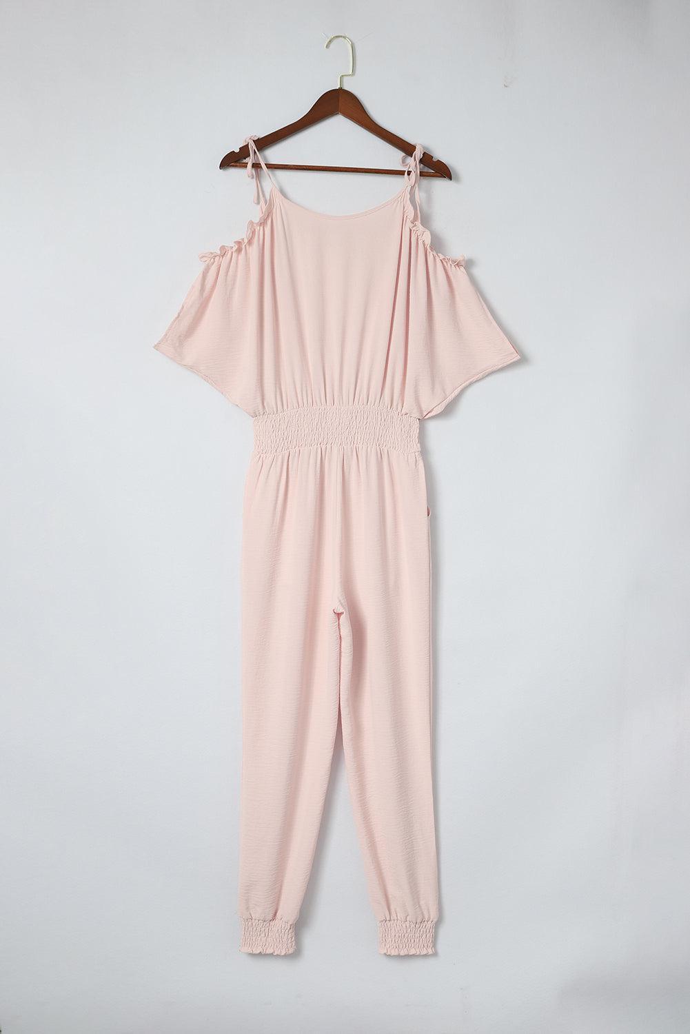 a pink jumpsuit hanging on a hanger