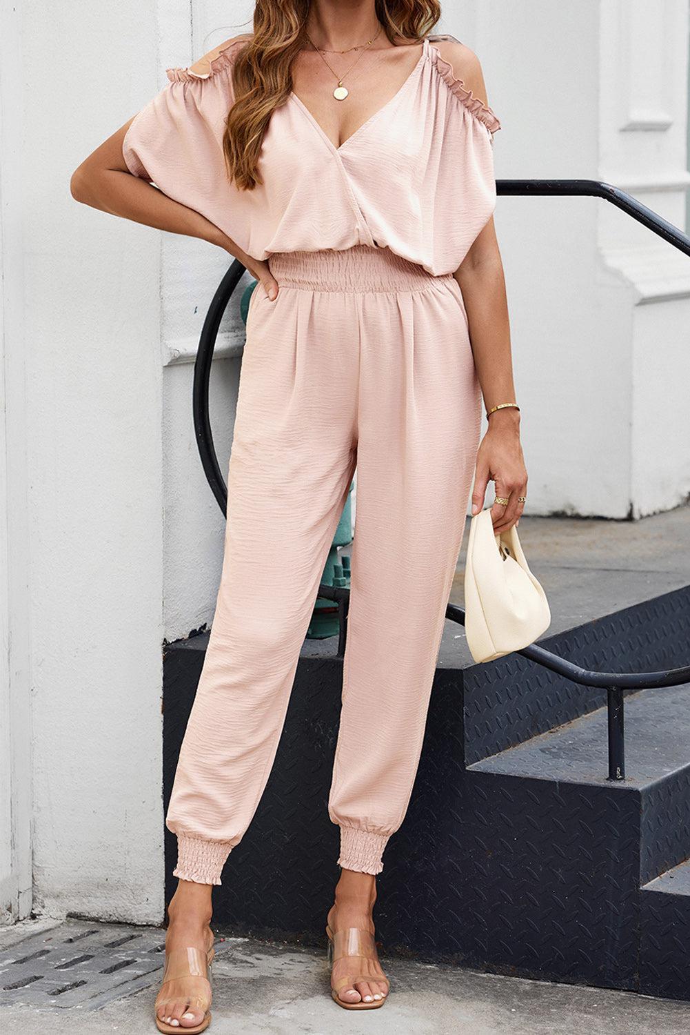 a woman in a pink jumpsuit posing for a picture