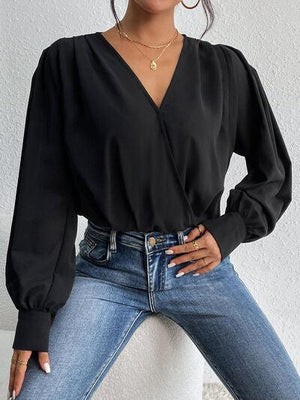 a woman wearing a black blouse and jeans