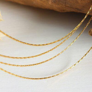 a close up of a gold necklace on a table