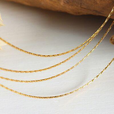 a close up of a gold necklace on a table