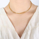 a woman wearing a white shirt and a gold necklace