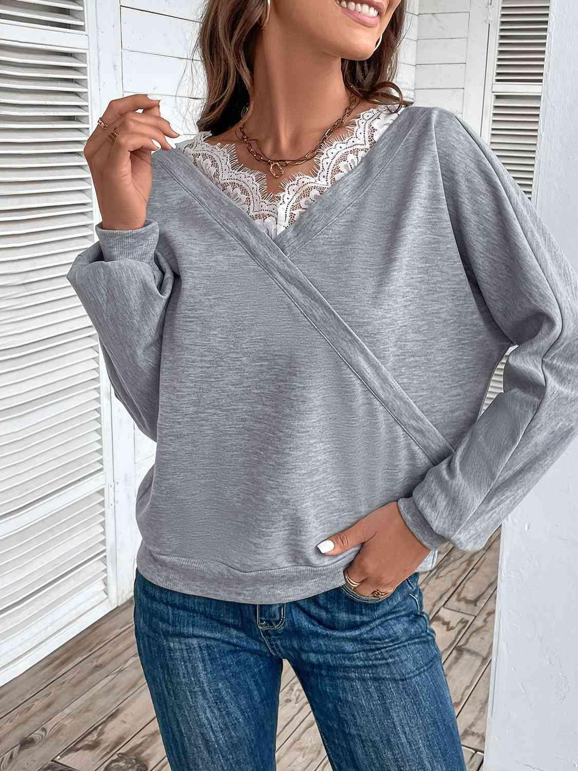 a woman wearing a grey sweater and jeans