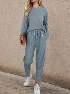 a woman wearing a blue jumpsuit and white sneakers